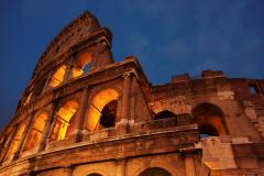 Low angel view of the Colosseum in Rome at dusk.