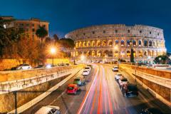 Rome, Italy. Colosseum Also Known As Flavian Amphitheatre. Traffic In Rome Near Famous World Landmark In Evening Time.