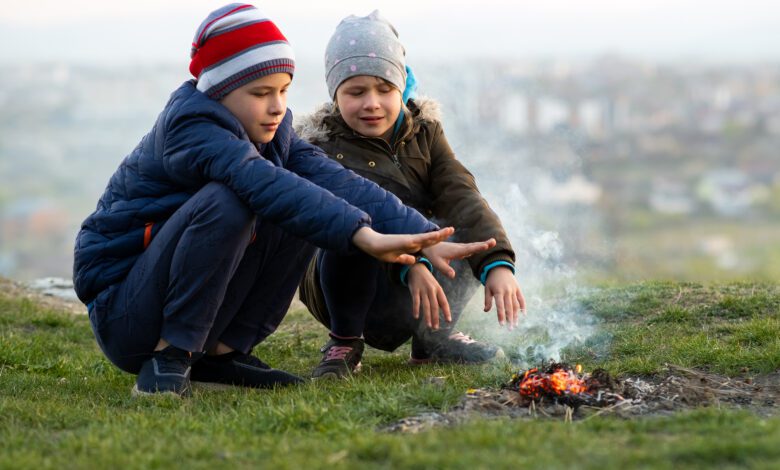 two children playing with fire outdoors in cold we 2022 10 31 22 23 50 utc Copia